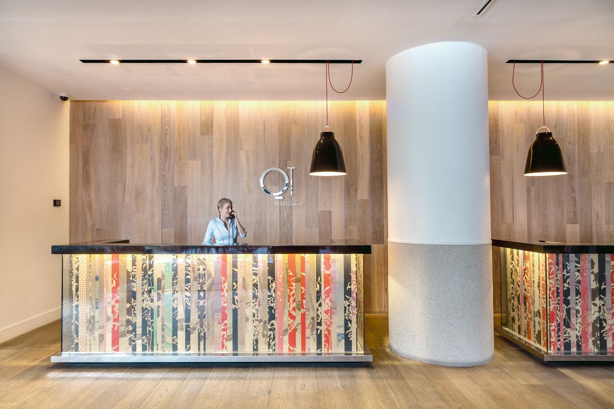 Reception desk with backlit striped panels and black pendant lights