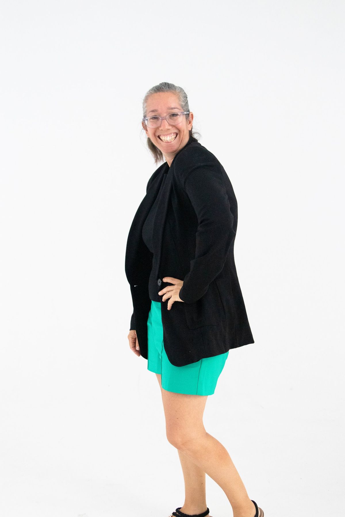 Sharon Lewin laughing, in a black blazer and green shorts