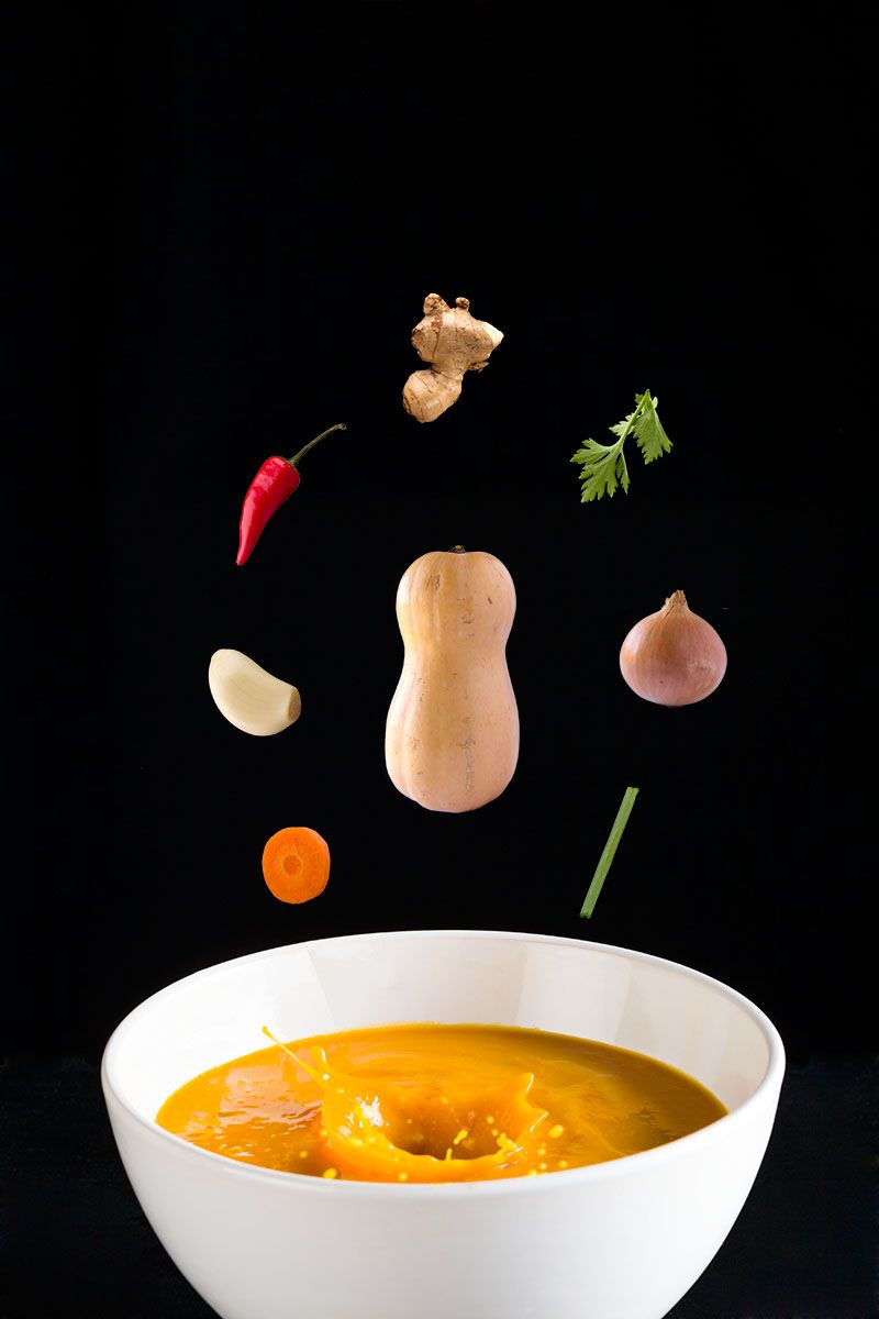 Butternut, chilli, ginger and garlic suspended above a splashing bowl of soup